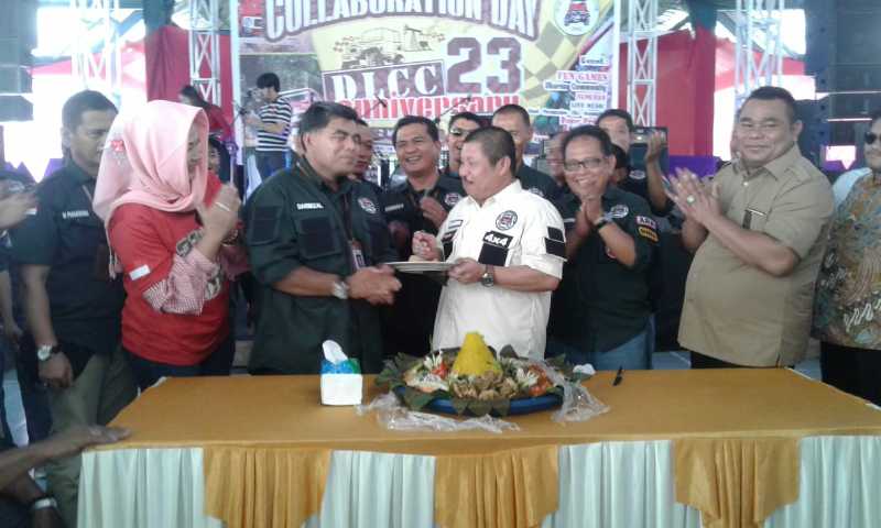Amril Mukminin menyuapkan Tumpeng kepada Ketua DLCC H. Darmizal